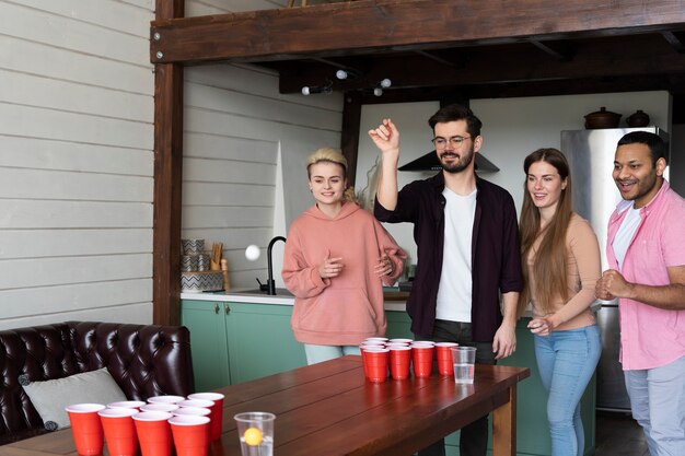 friends-playing-beer-pong-together-party_23-2149431364